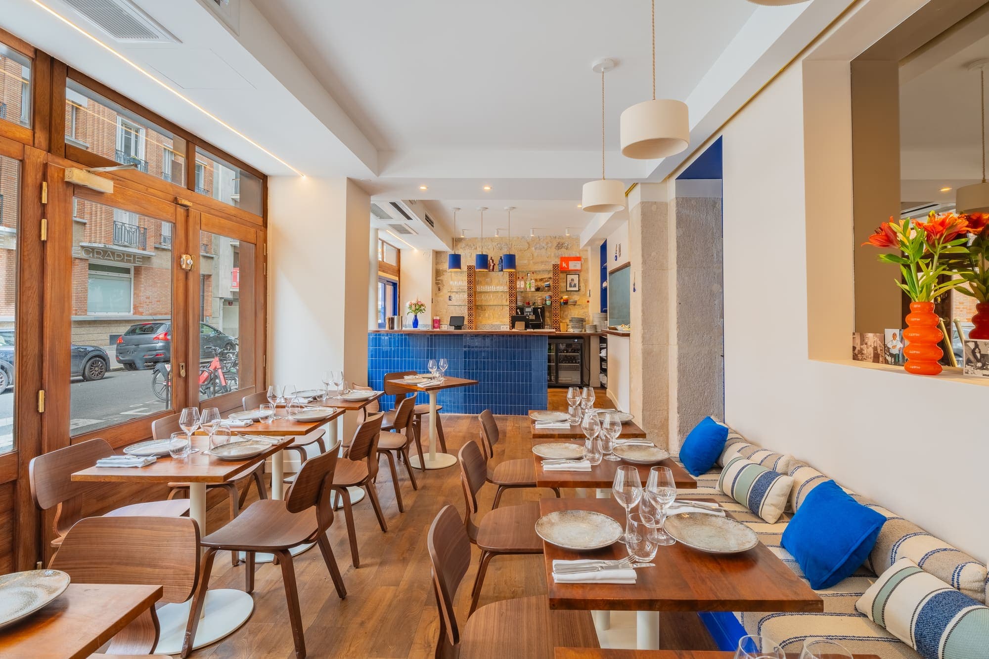 Salle du restaurant vue vers le bar carrelé de bleu.
